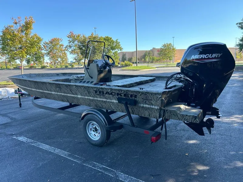 Slide: The Image of 2025 Tracker Grizzly 1860 CC boat with Mercury engine on trailer in parking lot. - 2