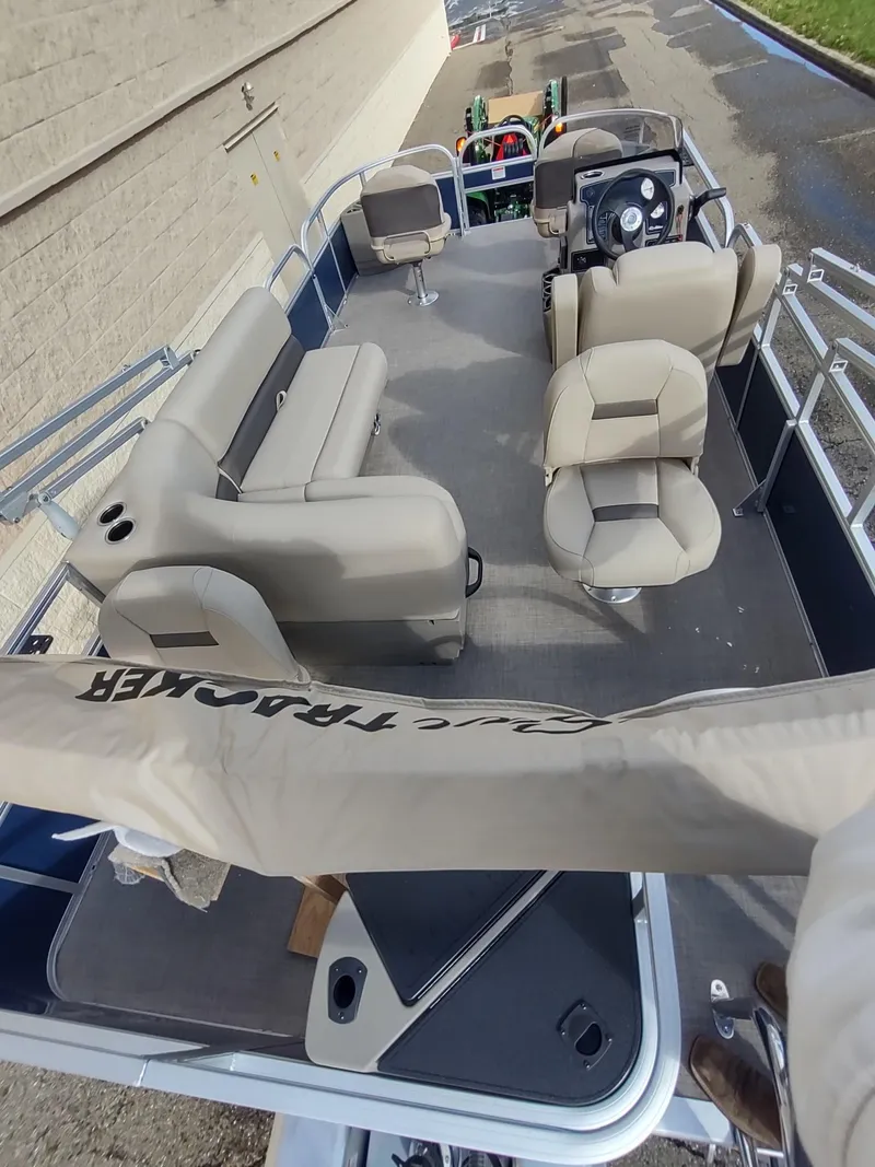 Slide: The Image of 2025 Sun Tracker Bass Buggy 18 DLX pontoon boat with beige seating and steering console. - 6
