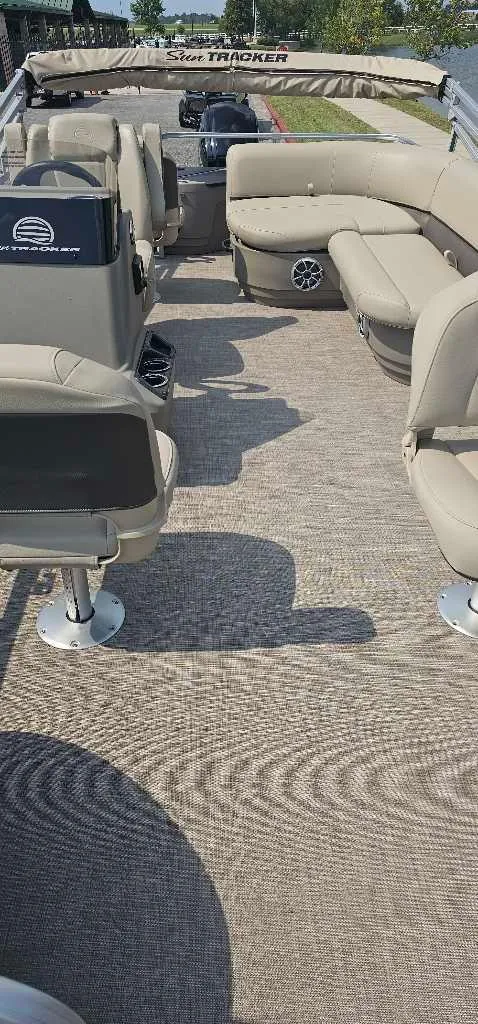 Slide: The Image of 2025 Sun Tracker Bass Buggy 18 DLX pontoon boat interior with beige seating. - 3