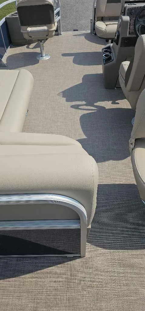 Slide: The Image of 2025 Sun Tracker Bass Buggy 18 DLX interior with beige seating and carpeted flooring. - 4