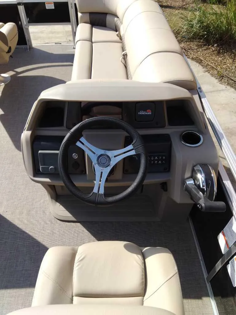 Slide: The Image of 2025 Sun Tracker SportFish 20 DLX boat interior with steering wheel and seating. - 2