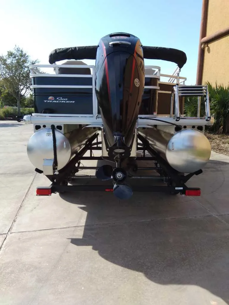 Slide: The Image of 2025 Sun Tracker SportFish 20 DLX pontoon boat, rear view with motor and pontoons. - 7