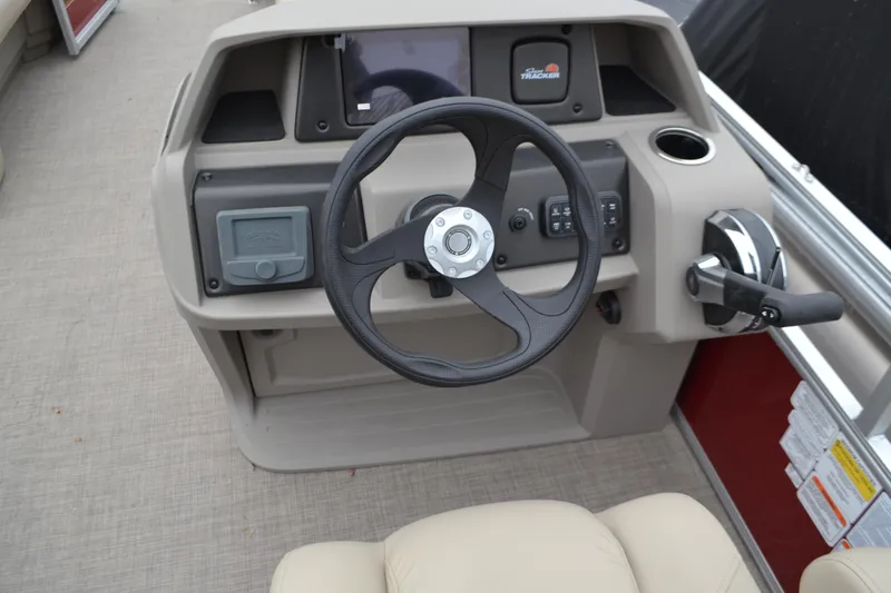 Slide: The Image of 2025 Sun Tracker Party Barge 18 DLX steering console with controls and display. - 2