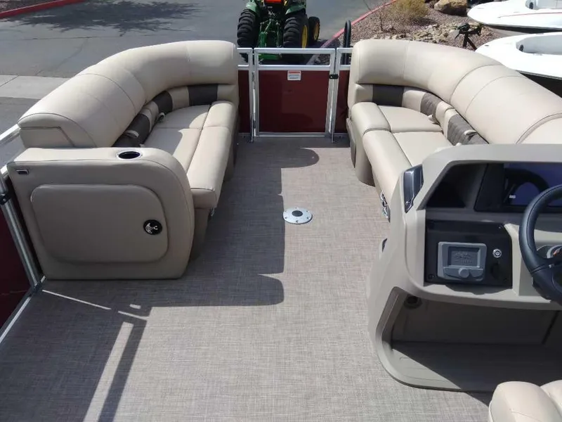 Slide: The Image of 2025 Sun Tracker Party Barge 22 RF DLX interior with beige seating and steering console. - 5