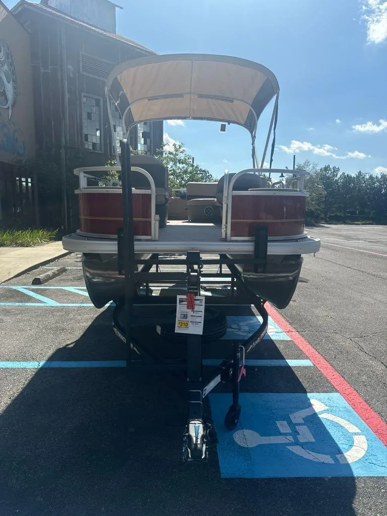 Slide: The Image of 2025 Sun Tracker Bass Buggy 18 DLX pontoon boat parked in a lot. - 3