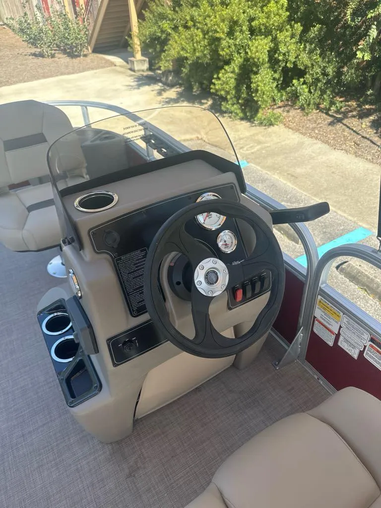 Slide: The Image of 2025 Sun Tracker Bass Buggy 18 DLX steering console with cup holders and seating. - 7