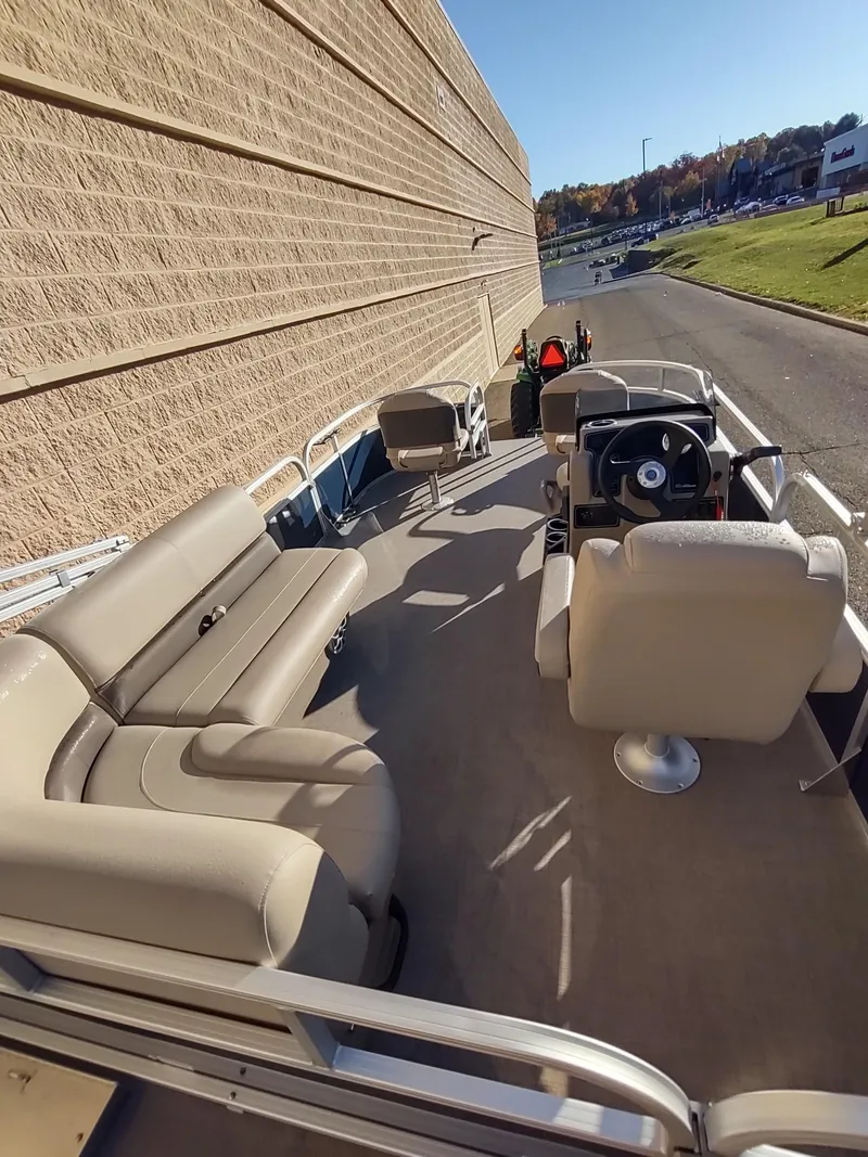 Slide: The Image of 2025 Sun Tracker Bass Buggy 16 XL Select pontoon boat with beige seating and steering console. - 4