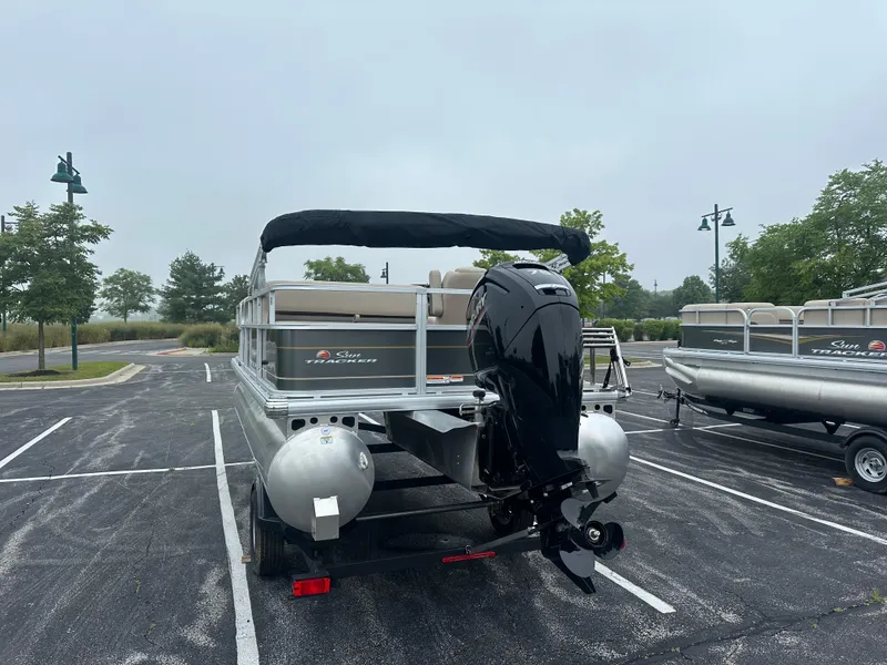 Slide: The Image of 2025 Sun Tracker Party Barge 18 DLX pontoon boat in parking lot. - 3