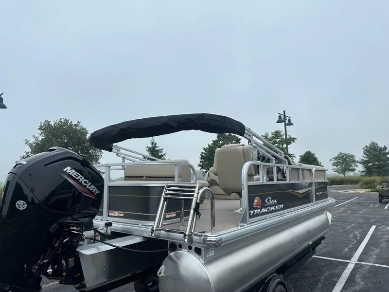 Slide: The Image of 2025 Sun Tracker Party Barge 18 DLX pontoon boat with Mercury engine in parking lot. - 4