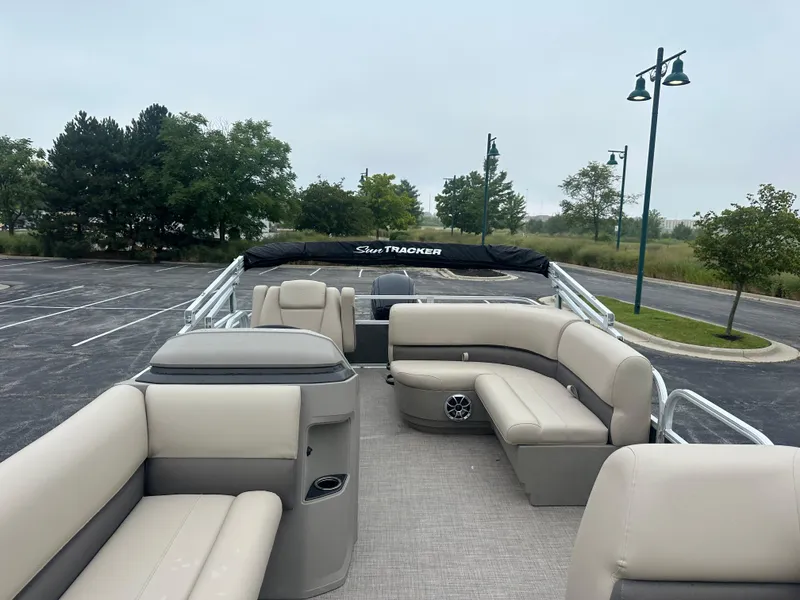 Slide: The Image of 2025 Sun Tracker Party Barge 18 DLX with spacious seating in a serene outdoor setting. - 5