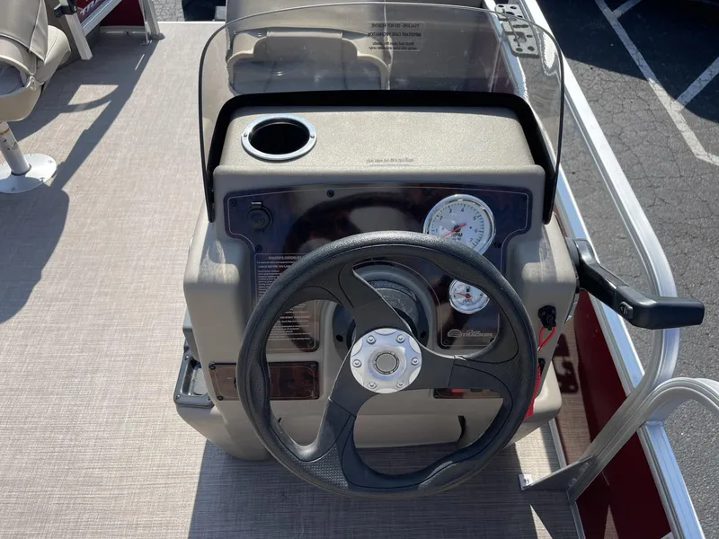 Slide: The Image of 2025 Sun Tracker Bass Buggy 18 DLX steering console with gauges and cup holder. - 13