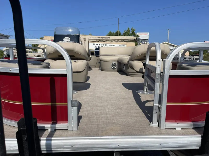 Slide: The Image of 2025 Sun Tracker Bass Buggy 18 DLX pontoon boat with red exterior and beige seating. - 5