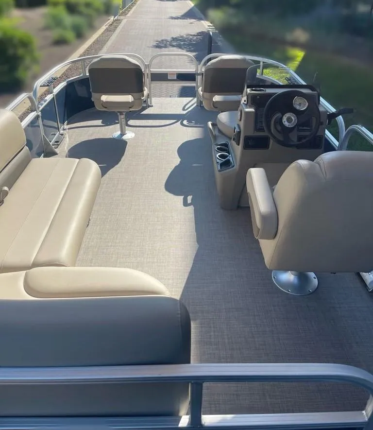 Slide: The Image of 2025 Sun Tracker Bass Buggy 16 XL Select pontoon boat interior with seating and steering console. - 2