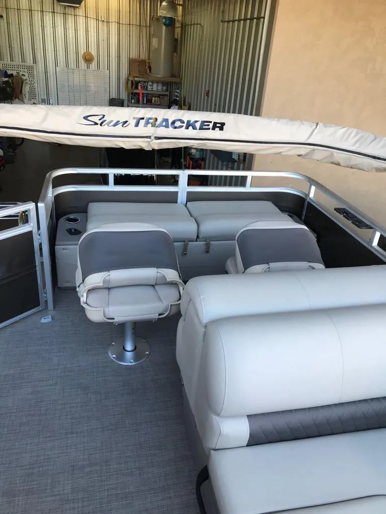 Slide: The Image of 2025 Sun Tracker SportFish 22 DLX pontoon boat interior with seating and canopy. - 10