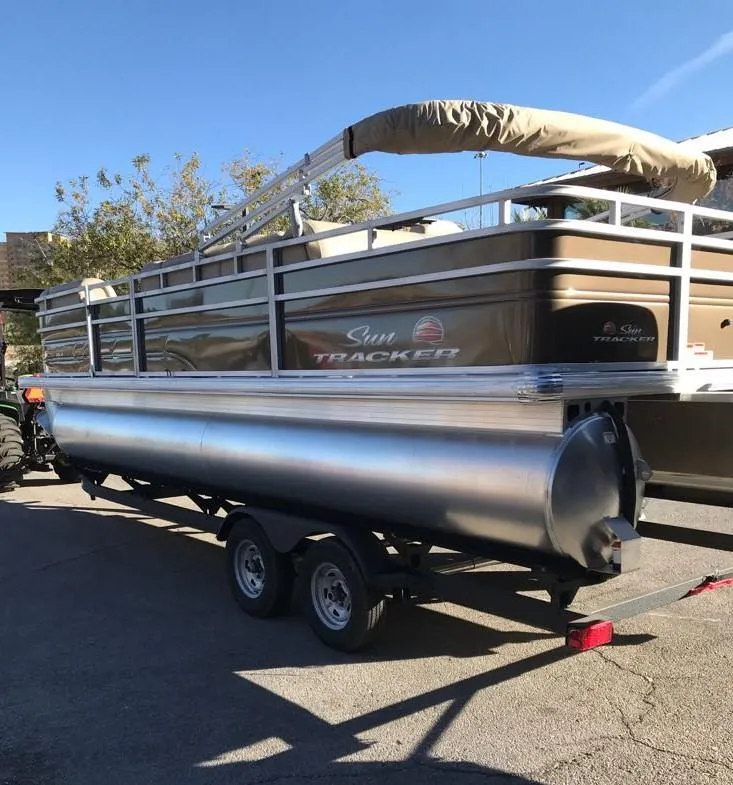 Slide: The Image of 2025 Sun Tracker SportFish 22 DLX pontoon boat on trailer, parked outdoors. - 3