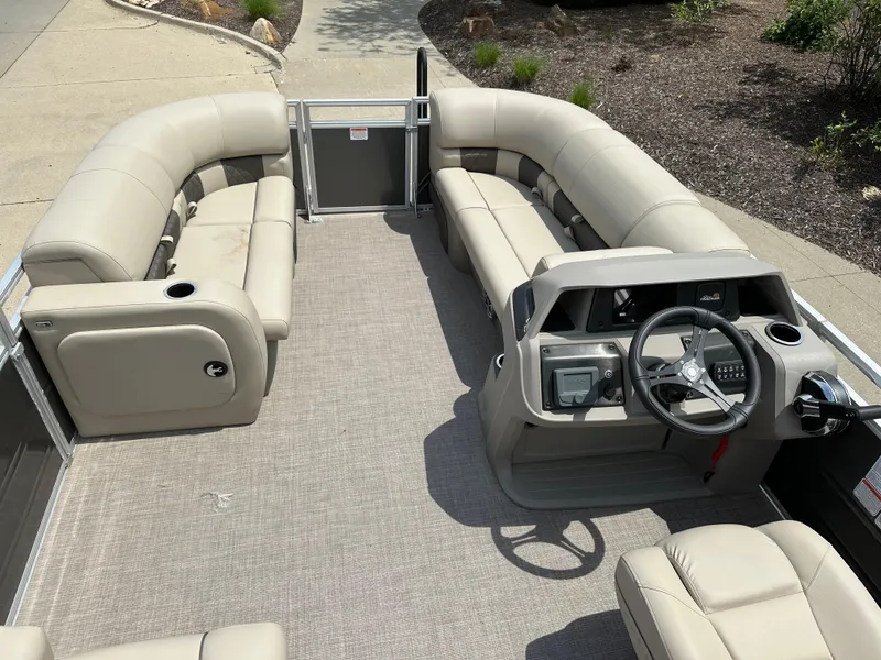 Slide: The Image of 2025 Sun Tracker Party Barge 22 RF DLX interior with beige seating and steering console. - 4