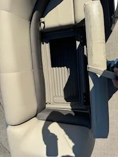 Slide: The Image of 2025 Sun Tracker Party Barge 18 DLX seat storage compartment, beige upholstery. - 13