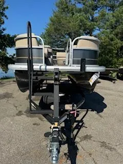Slide: The Image of 2025 Sun Tracker Party Barge 18 DLX pontoon boat on trailer, parked outdoors. - 16
