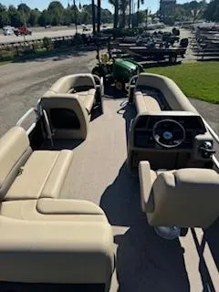 Slide: The Image of 2025 Sun Tracker Party Barge 18 DLX pontoon boat with beige seating and steering console. - 6