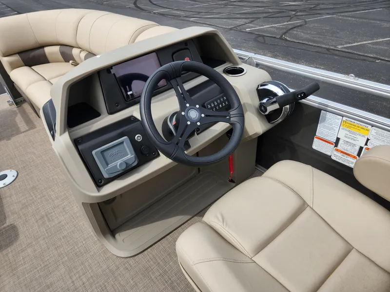 Slide: The Image of 2025 Sun Tracker Party Barge 22 RF DLX steering console with beige seating and controls. - 3