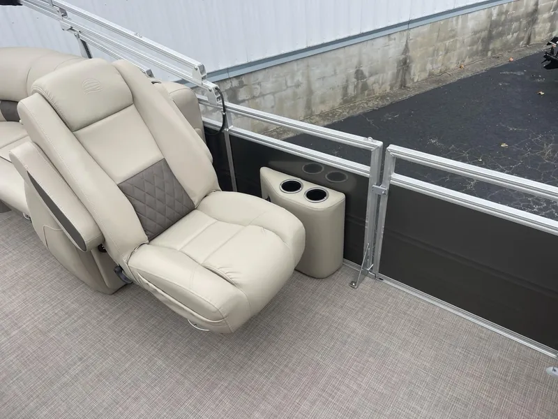 Slide: The Image of 2025 Sun Tracker Party Barge 22 DLX interior with beige seating and cup holders. - 11