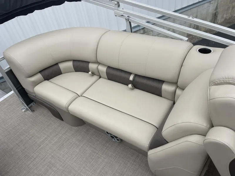 Slide: The Image of 2025 Sun Tracker Party Barge 22 DLX beige seating with cup holder, luxurious boat interior. - 13
