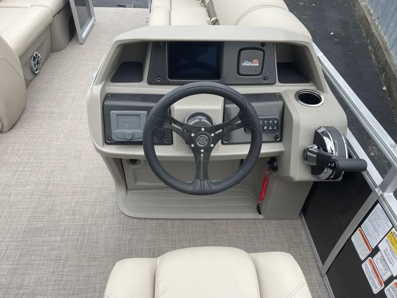 Slide: The Image of 2025 Sun Tracker Party Barge 22 DLX helm with steering wheel and control panel. - 15