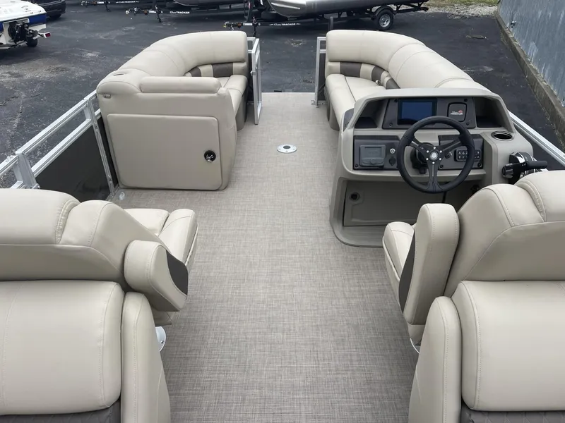 Slide: The Image of 2025 Sun Tracker Party Barge 22 DLX interior with beige seating and modern dashboard. - 16