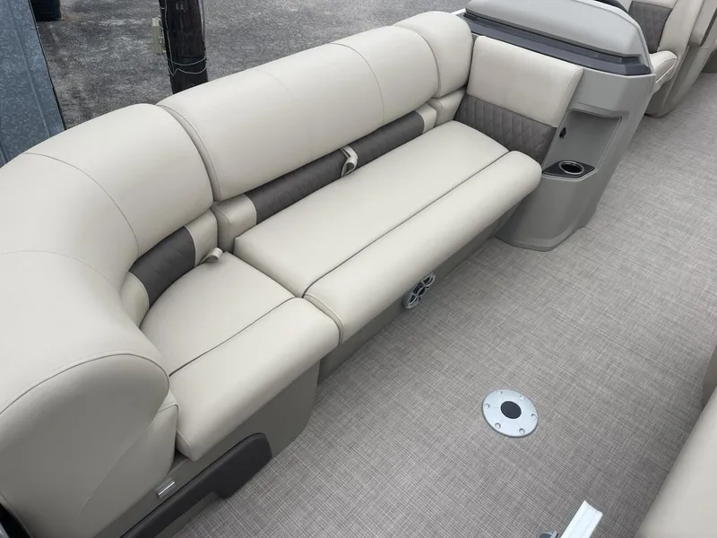 Slide: The Image of 2025 Sun Tracker Party Barge 22 DLX interior with beige seating and cup holders. - 7