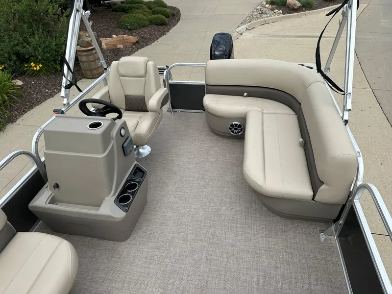 Slide: The Image of 2025 Sun Tracker Party Barge 16 DLX with beige seating and steering console. - 7