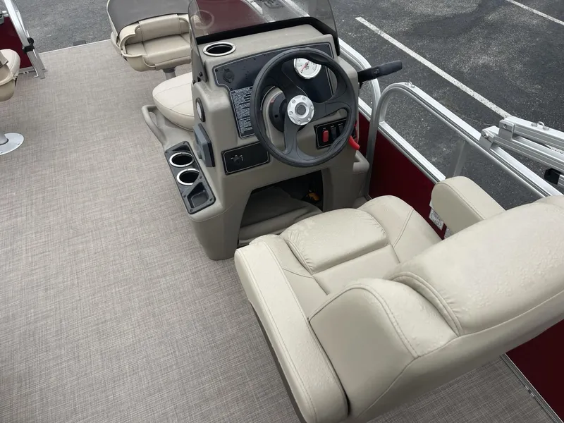 Slide: The Image of 2025 Sun Tracker Bass Buggy 16 XL Select boat interior with beige seating and steering console. - 10
