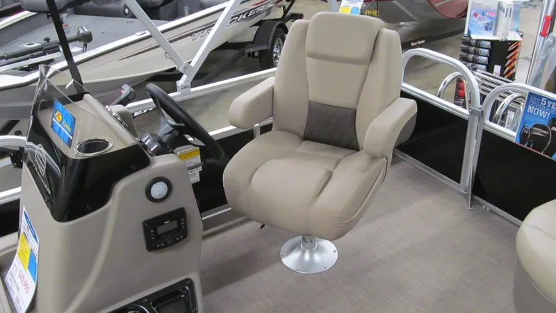 Slide: The Image of 2025 Sun Tracker Party Barge 16 DLX interior with captain's chair and control console. - 6