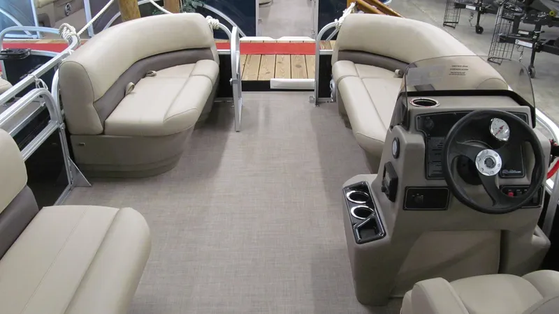 Slide: The Image of 2025 Sun Tracker Party Barge 16 DLX interior with beige seating and steering console. - 9