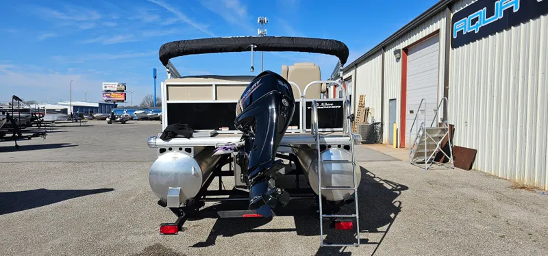 Slide: The Image of 2025 Sun Tracker Party Barge 16 DLX pontoon boat with outboard motor in a marina. - 3