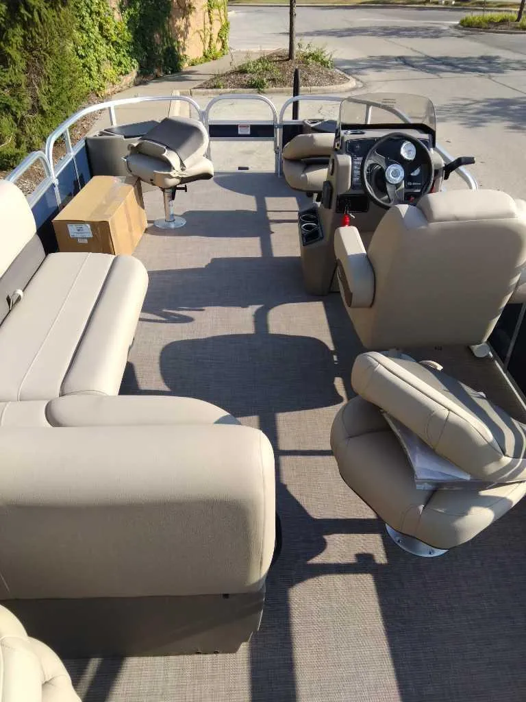 Slide: The Image of 2025 Sun Tracker Bass Buggy 18 DLX pontoon boat interior with beige seating. - 2