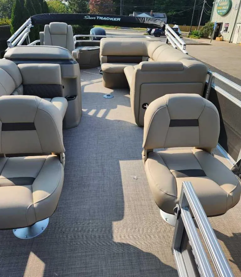 Slide: The Image of 2025 Sun Tracker Fishin' Barge 20 DLX with beige seating and spacious deck. - 2