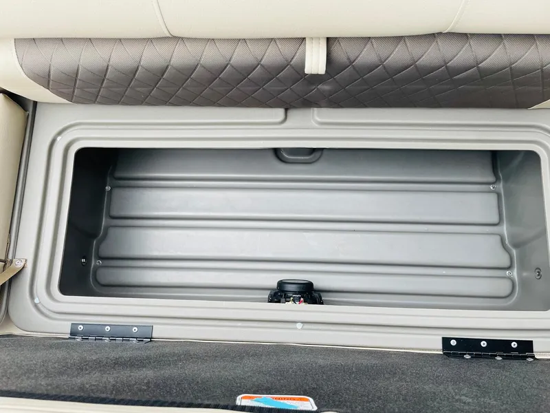 Slide: The Image of 2025 Sun Tracker SportFish 20 DLX storage compartment with cushioned seating. - 14
