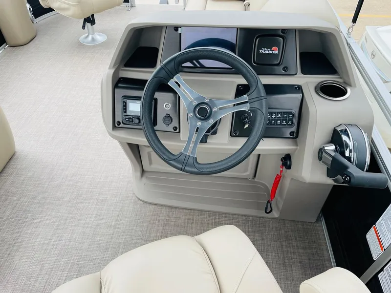 Slide: The Image of 2025 Sun Tracker SportFish 20 DLX boat dashboard with steering wheel and controls. - 24