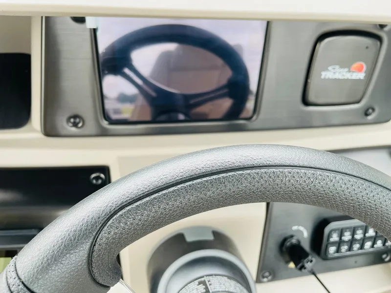Slide: The Image of 2025 Sun Tracker SportFish 20 DLX dashboard with steering wheel and controls. - 26