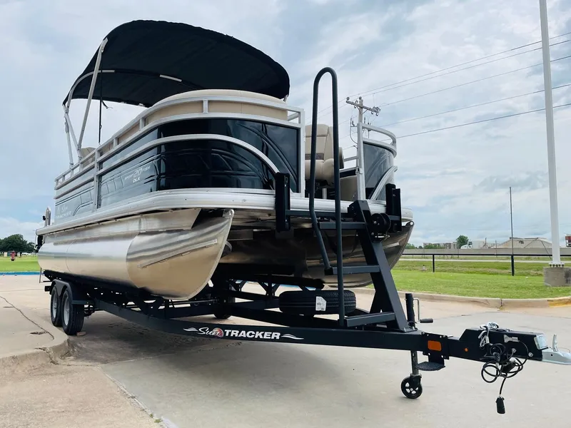 Slide: The Image of 2025 Sun Tracker SportFish 20 DLX pontoon boat on trailer, parked outdoors. - 3