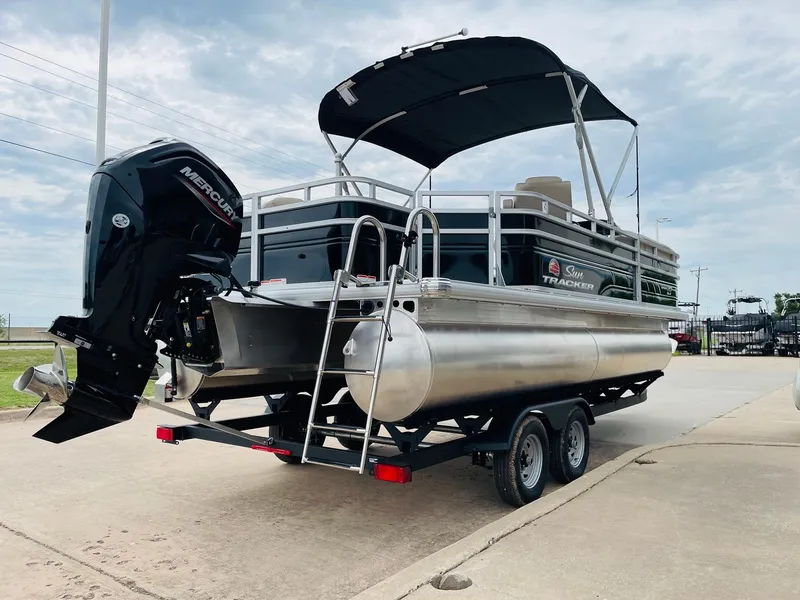 Slide: The Image of 2025 Sun Tracker SportFish 20 DLX pontoon boat on trailer, featuring Mercury outboard motor. - 5