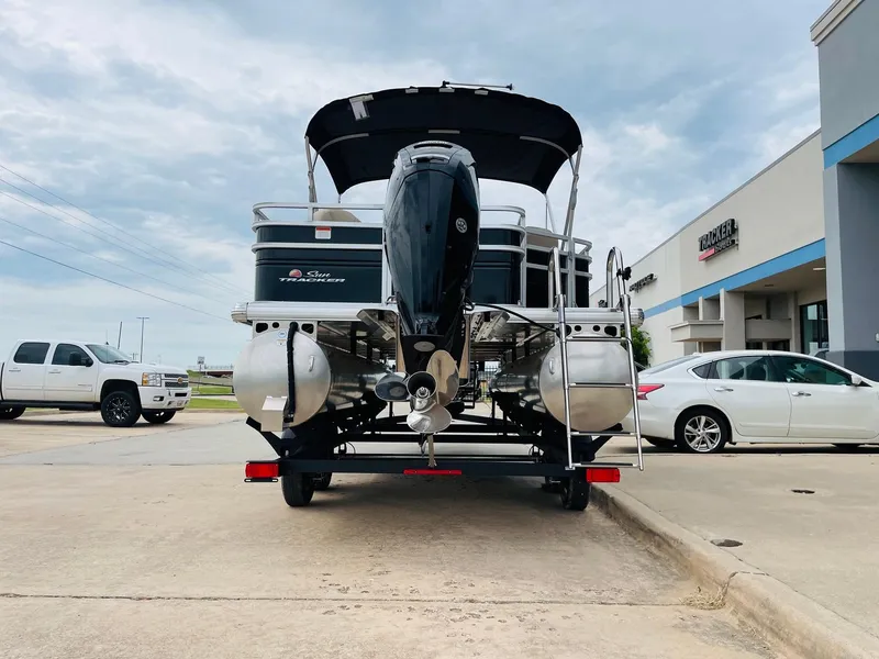 Slide: The Image of 2025 Sun Tracker SportFish 20 DLX pontoon boat on trailer, parked in dealership lot. - 6