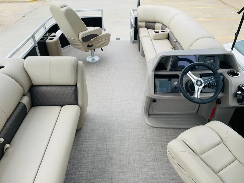 Slide: The Image of 2025 Sun Tracker SportFish 20 DLX pontoon boat interior with beige seating and steering console. - 9