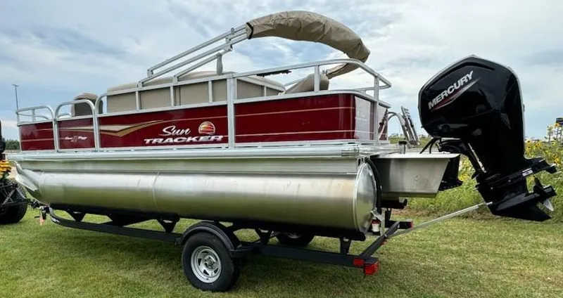 Slide: The Image of 2025 Sun Tracker Bass Buggy 18 DLX pontoon boat with Mercury outboard motor on trailer. - 3