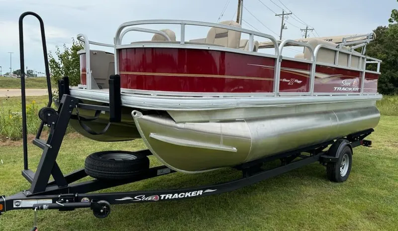 Slide: The Image of 2025 Sun Tracker Bass Buggy 18 DLX pontoon boat on trailer, red and silver design. - 4