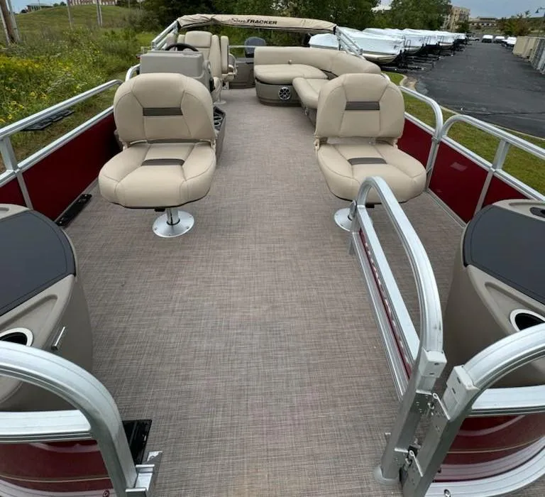 Slide: The Image of 2025 Sun Tracker Bass Buggy 18 DLX pontoon boat with beige seating and red accents. - 6
