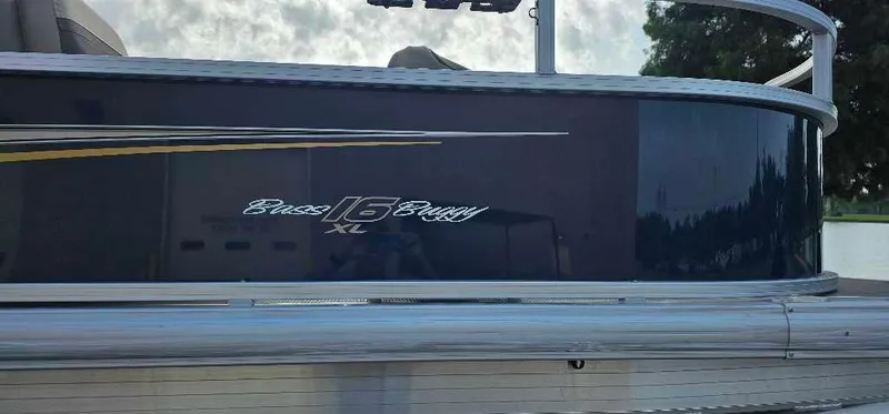 Slide: The Image of 2025 Sun Tracker Bass Buggy 16 XL Select pontoon boat side view. - 2