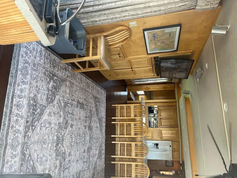 Slide: The Image of Interior of a 2002 Sharpe houseboat with wooden cabinets and a patterned rug. - 10