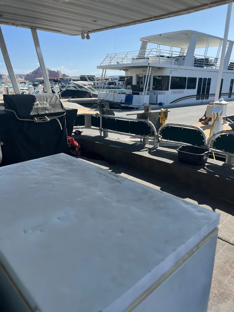 Slide: The Image of 2002 Sharpe houseboat docked under a canopy on a sunny day. - 12