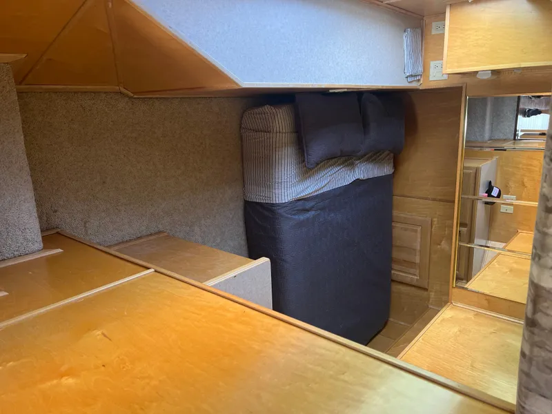 Slide: The Image of Interior of a 2002 Sharpe houseboat featuring a cozy sleeping area with wooden accents. - 13